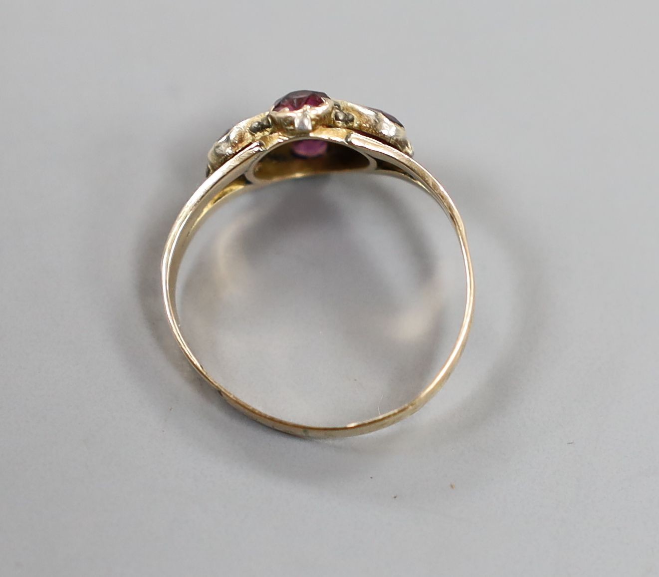 A Victorian 12ct gold and four stone garnet and amethyst set dress ring, size O, gross 1.7 grams.